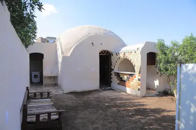 a white building with an arch and a door at Happy house in Luxor