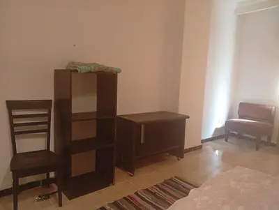 a bedroom with a book shelf and a chair at Sheraton Plaza Retreat in Hurghada