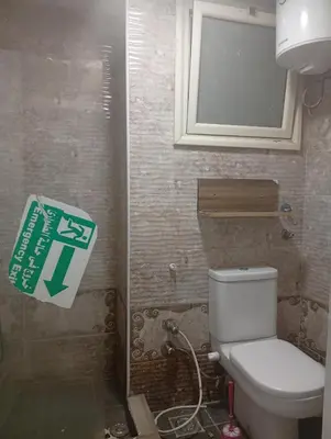a bathroom with a toilet and a sign on the wall at Sheraton Plaza Retreat in Hurghada
