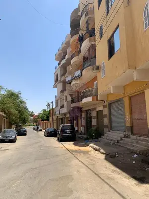 a building with cars parked on the side of a street at Welcome to LLL (Love Life Luxor) in Luxor