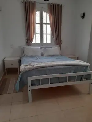 a bed in a room with a window and a bed frame at Luxor Palm Villa in Luxor