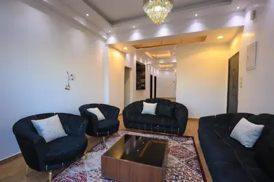 a living room with black couches and a coffee table at Pearl of Luxor on the Nile -Apartment in Luxor