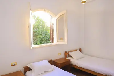 a room with two beds and a window at Pearl of Luxor on the Nile -Apartment in Luxor
