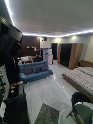 a living room with a blue couch and a bed at Horizon on Mamsha in Hurghada