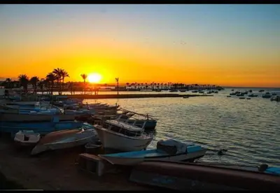 a group of boats docked on a beach at sunset at Sea Life Hurghada Apartments in Hurghada