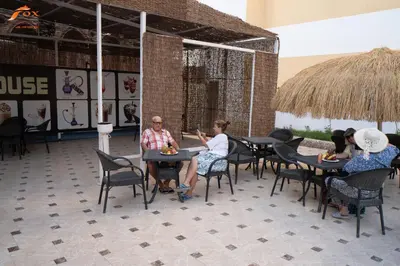 a group of people sitting at tables in a restaurant at Captain Beach Resort Suite in Hurghada