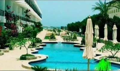 a swimming pool in a resort with an umbrella at Captain Beach Resort Suite in Hurghada