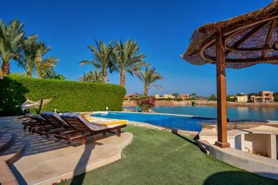 a swimming pool with lounge chairs and an umbrella at Wast golf Y 41 in Hurghada