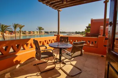 a table and chairs on a balcony with a view of the beach at Wast golf Y 41 in Hurghada