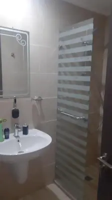 a bathroom with a shower and a sink and a mirror at Egypt Traveler Hotel in Hurghada