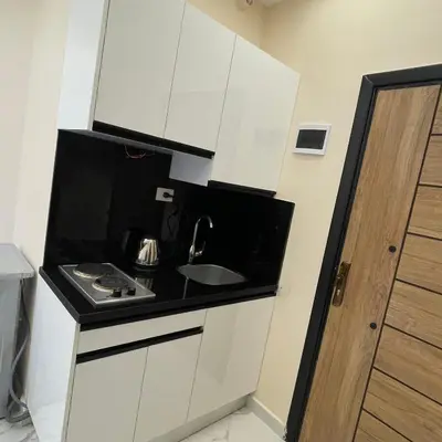 a small kitchen with white cabinets and a sink at منتجع جوليانا بيتش ريزورت in Hurghada