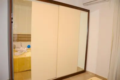 a closet with a mirror in a room with a bed at Luxe Apartment Inside Karma Beach Resort Al Ahiaa-Beach Free Access in Hurghada