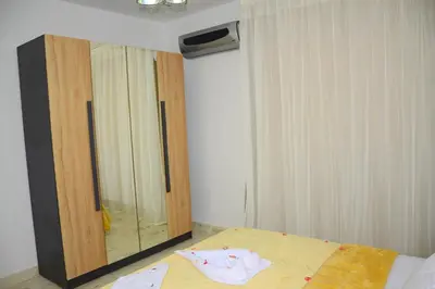 a bedroom with a dresser and a bed and a mirror at Luxe Apartment Inside Karma Beach Resort Al Ahiaa-Beach Free Access in Hurghada