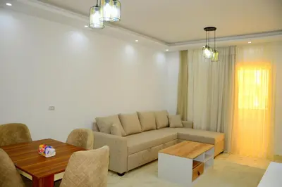 a living room with a couch and a table at Luxe Apartment Inside Karma Beach Resort Al Ahiaa-Beach Free Access in Hurghada