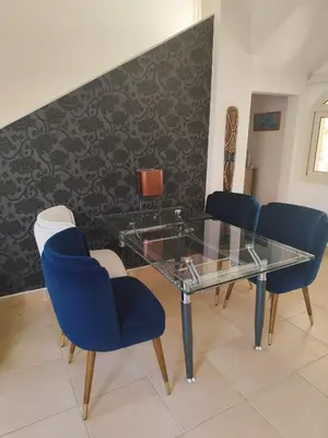 a dining room with a glass table and blue chairs at Villa Makadi Heights in Hurghada