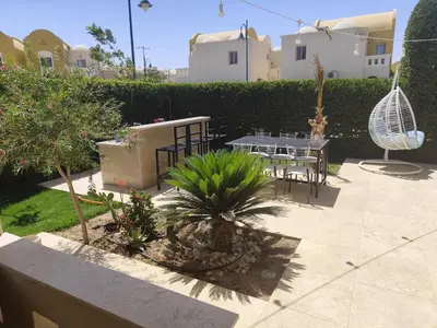 a patio with a table and chairs and plants at Villa Makadi Heights in Hurghada