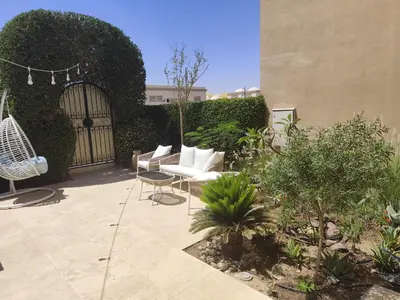 a patio with a white couch and chairs in a yard at Villa Makadi Heights in Hurghada