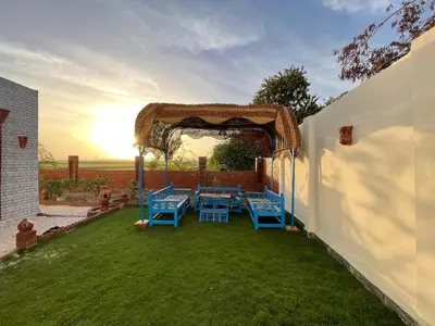 an outdoor patio with blue tables and an arbor at Julia House in Luxor