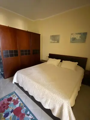 a bedroom with a large bed with a wooden headboard at Gravity Beach Apartment Non Egyptians only in Hurghada