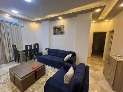 a living room with a blue couch and a table at Spacious 2-Bedroom Apartment - Families Only in Hurghada