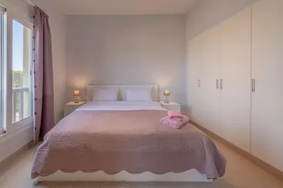 a bedroom with a bed with a pink towel on it at El-Gouna Water-Side Apartment in Hurghada