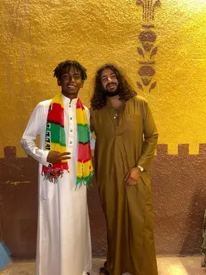 two men dressed in costumes standing next to a wall at Bafana Bafana Nubian Hostel in Najâ€˜ al MadÄbb
