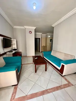 a living room with two beds and a tv at H&H Dream in Hurghada