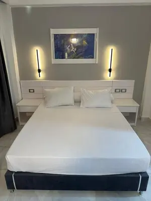 a large white bed in a room with two lights at Elixir in Hurghada