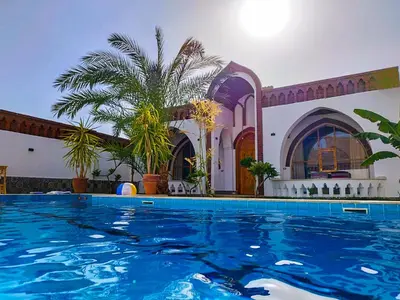 a large swimming pool in front of a building at Villa Kemet in Jazīrat al ‘Awwāmīyah