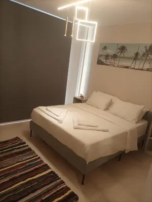 a bedroom with a bed with white sheets and a chandelier at Mangroovy retreat in Hurghada