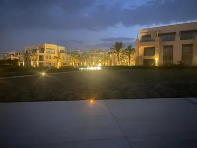 a lit up parking lot in front of a building at night at Mangroovy retreat in Hurghada