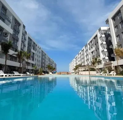 a large swimming pool in front of some apartment buildings at Fanadir Bay in Hurghada