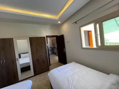 a bedroom with a bed and a window and a mirror at Chalet in mirage resort bay resort & aqua park in Hurghada