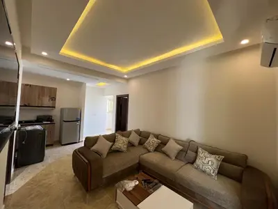 a living room with a couch and a kitchen at Chalet in mirage resort bay resort & aqua park in Hurghada