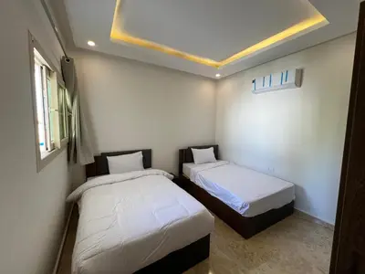 two beds in a small room with white walls at Chalet in mirage resort bay resort & aqua park in Hurghada