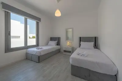 a white room with two beds and a window at Luxury Villa with private pool Sholan 2 in Hurghada