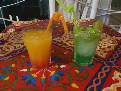 a table with two drinks on a table at Moon Boat in Luxor