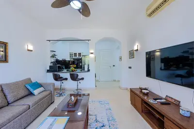 a living room with a couch and a large flat screen tv at Beautiful apartment with terrace to the pool in Hurghada