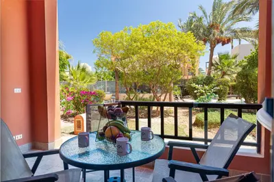 a table with a bowl of fruit on a balcony at Beautiful apartment with terrace to the pool in Hurghada