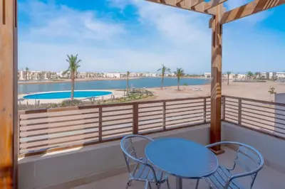 a balcony with a table and chairs and a view of the beach at Sunny 1BR Retreat Newest Project Shedwan El Gouna Lagoon & Pool in Hurghada