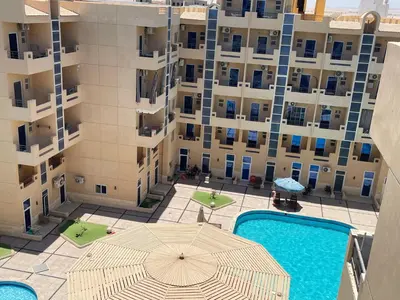 an overhead view of a building with an umbrella and a pool at Wavesong Whispers flat where you can enjoy seaview with the best price and enjoy speedy wifi in Hurghada