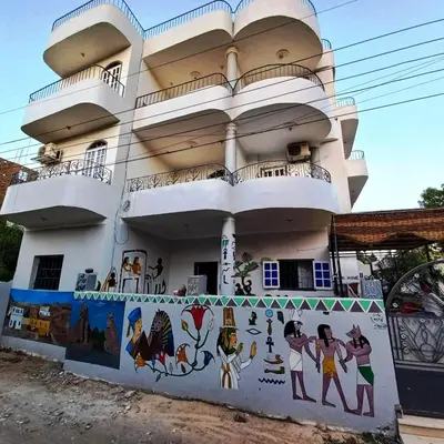 a building with a mural on the side of it at Pauline Guest House in Luxor