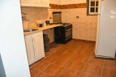 a kitchen with a sink and a stove at Pauline Guest House in Luxor