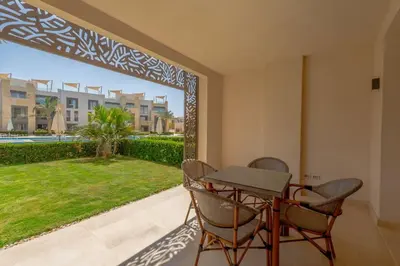 a dining room with a table and chairs on a patio at Stylish Gouna Escape 2BR Mangroovy Beach Pool Access in Hurghada
