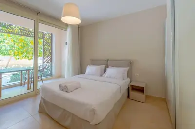 a bedroom with a large bed and a large window at Stylish Gouna Escape 2BR Mangroovy Beach Pool Access in Hurghada