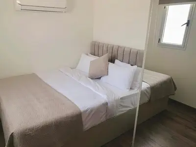 a bedroom with a bed with white sheets and pillows at Soma Bay - Luxury 3 Bedroom Penthouse - Panoramic Sea View, Free Pool and Beach Access in Hurghada