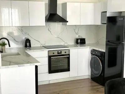 a white kitchen with a stove and a dishwasher at Soma Bay - Luxury 3 Bedroom Penthouse - Panoramic Sea View, Free Pool and Beach Access in Hurghada