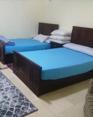 two beds in a room with blue sheets at بالما ريزورت in Hurghada