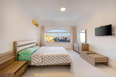 a bedroom with a bed and a flat screen tv at Aden Beach - Sea View room with beach access in Villa in Hurghada