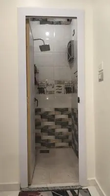 a glass door leading to a shower in a room at Aswan Key Cozy in Nag` el-Ramla